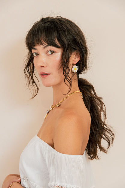 Woman wearing a white top with a neutral background