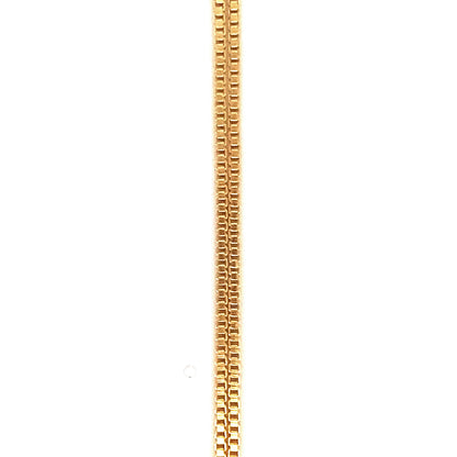 Extreme close-up detail of a gold box chain necklace showing the interlocking square link pattern against a white background