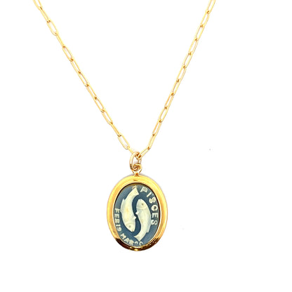 Gold necklace with a pendant featuring a fish illustration and text on a white background