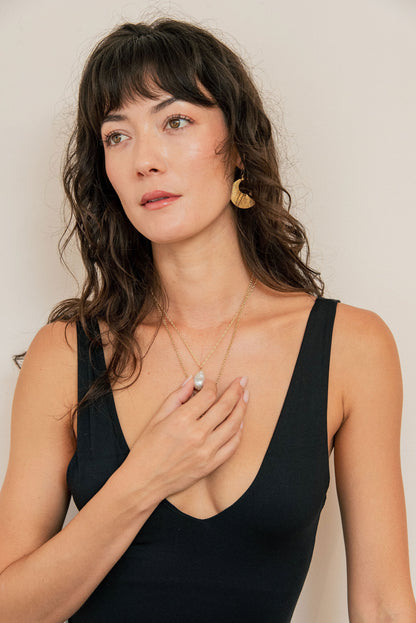 Woman wearing a black sleeveless top against a plain background