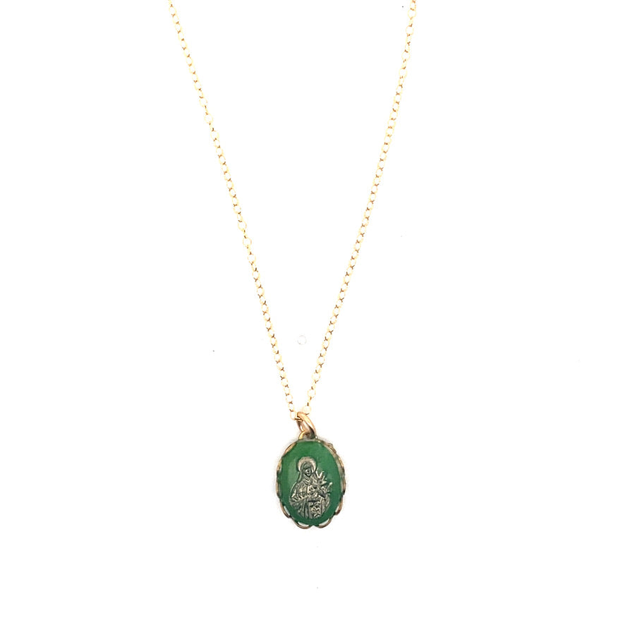 A vintage emerald green Virgin Mary cameo pendant necklace with gold overlay on a delicate gold chain against a white background