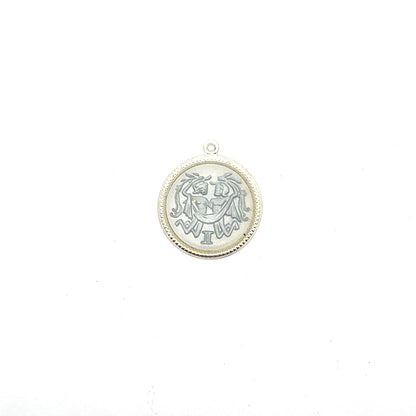 Silver round Gemini zodiac coin charm with twins design and Roman numeral II against a white background
