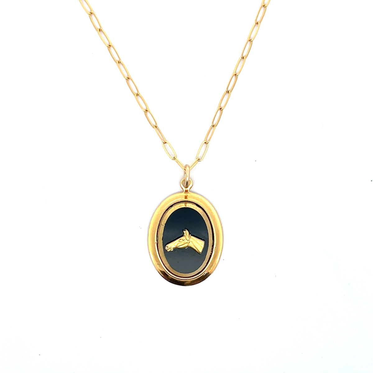 Gold necklace with a black pendant on a white background