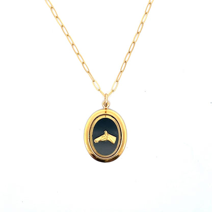Gold necklace with a black pendant on a white background