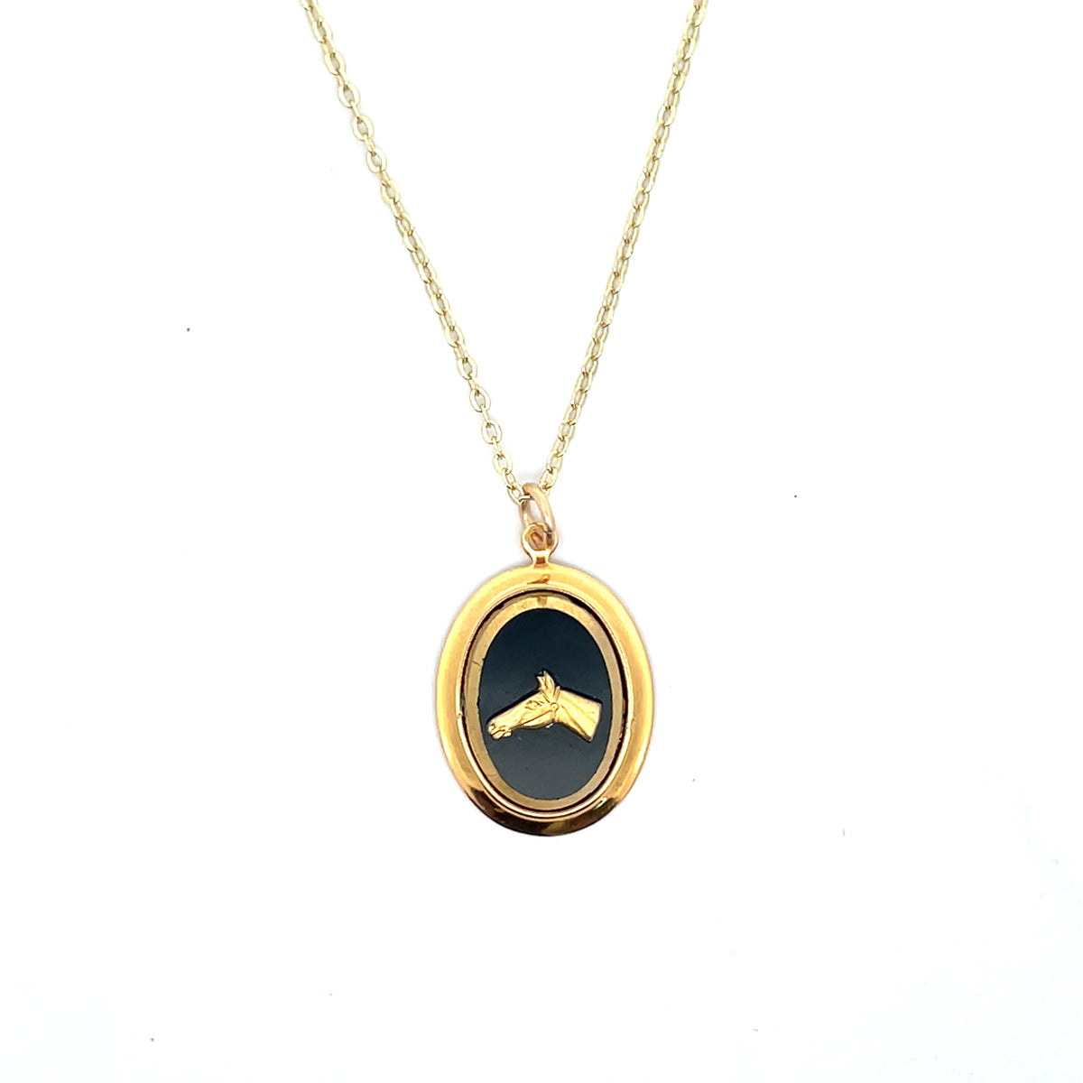 Gold necklace with a black pendant on a white background