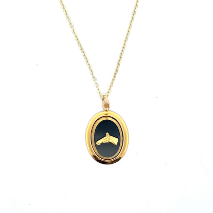 Gold necklace with a black pendant on a white background