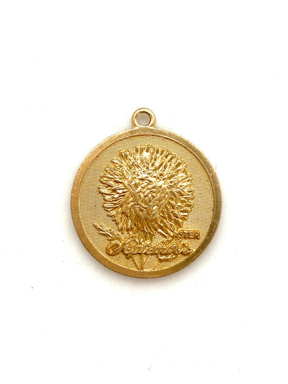Gold embossed September aster birth month flower coin pendant charm on a white background