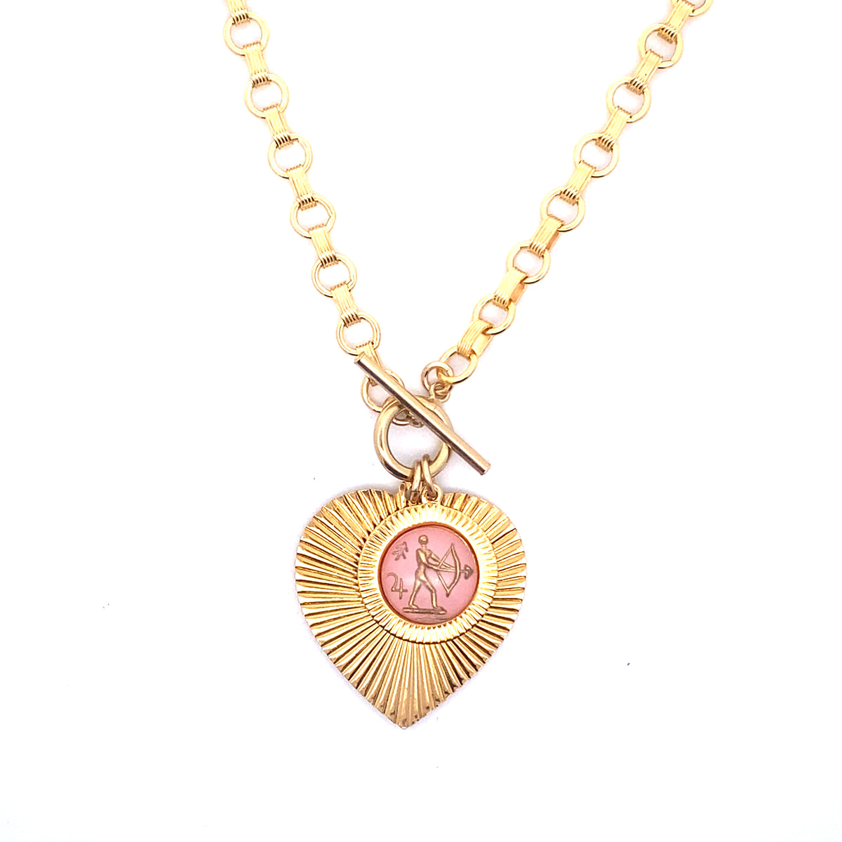 A gold ribbed heart-shaped pendant necklace with a Sagittarius zodiac archer design in pink enamel center with toggle clasp closure on a gold round link chain against a white background