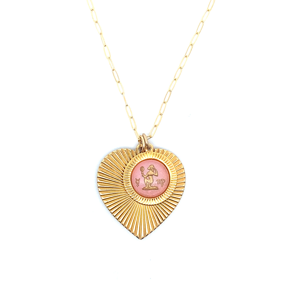 A gold ribbed heart-shaped pendant necklace with a Virgo zodiac maiden design in pink enamel center on a gold paperclip chain against a white background