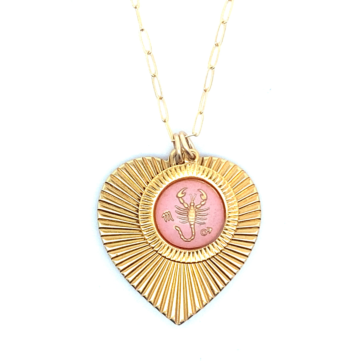 A gold ribbed heart-shaped pendant necklace with a Scorpio zodiac scorpion design in pink enamel center on a gold paperclip chain against a white background