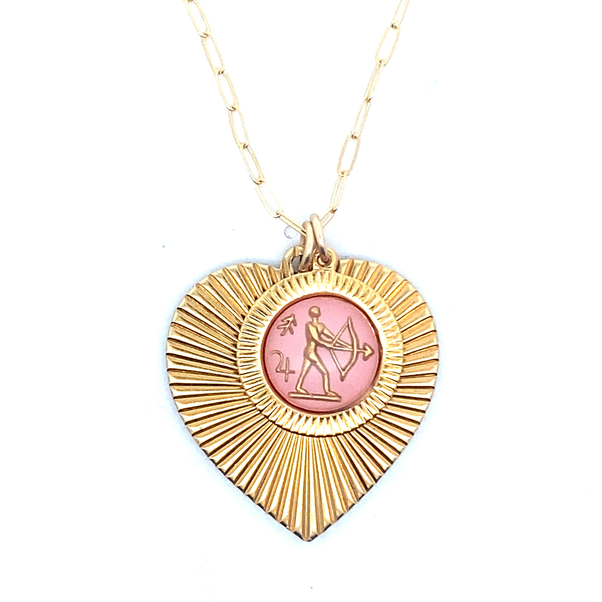 A gold ribbed heart-shaped pendant necklace with a Sagittarius zodiac archer design in pink enamel center on a gold paperclip chain against a white background