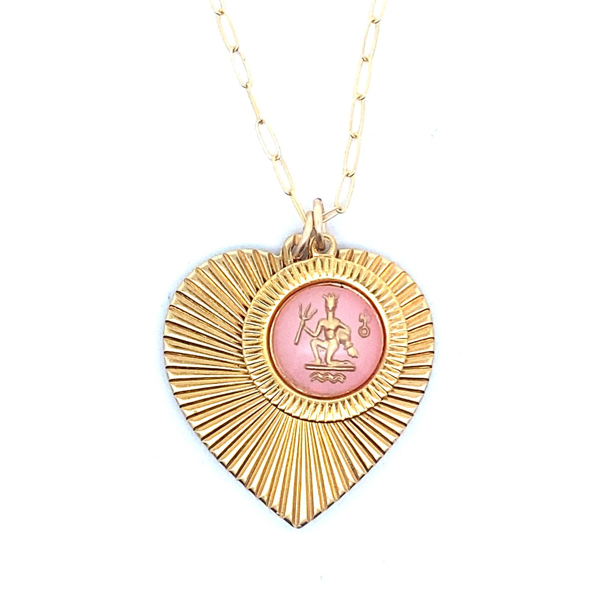 A gold ribbed heart-shaped pendant necklace with an Aquarius zodiac water bearer design in pink enamel center on a gold paperclip chain against a white background