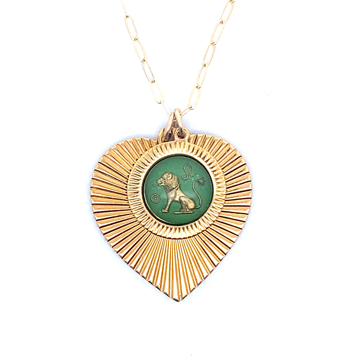 A gold ribbed heart-shaped pendant necklace with a Leo zodiac lion design in green enamel center on a gold paperclip chain against a white background