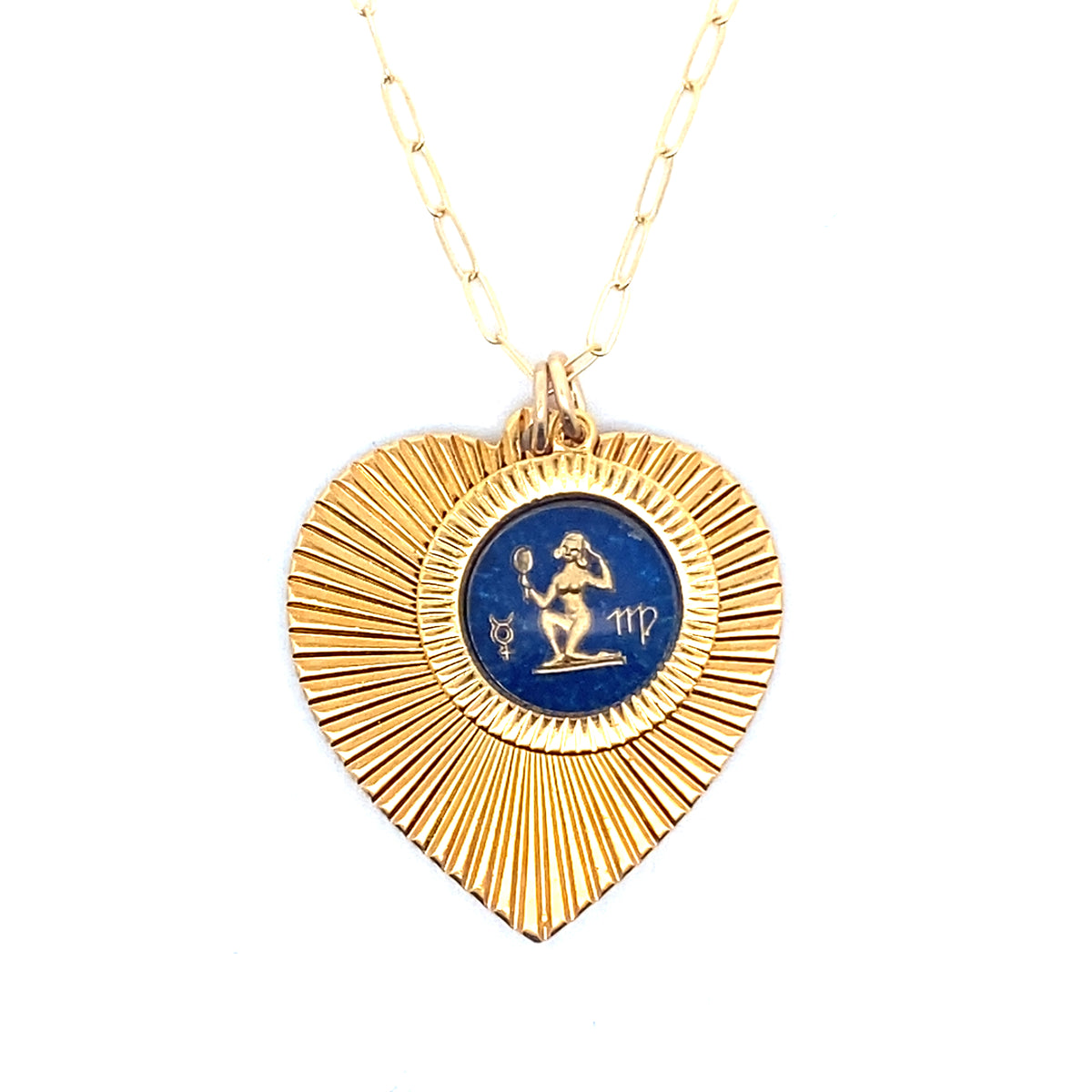 A gold ribbed heart-shaped pendant necklace with a Virgo zodiac maiden design in blue enamel center on a gold paperclip chain against a white background