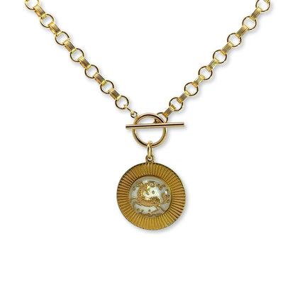 Gold rolo chain necklace with toggle clasp and gold round sunburst pendant with white iridescent vintage glass Taurus bull intaglio cameo on a white background