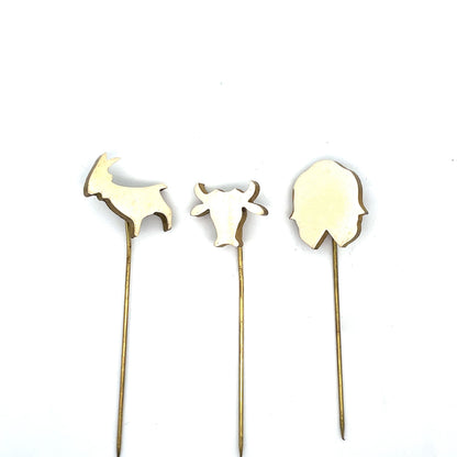 Three decorative picks shaped like leaves on thin sticks against a white background