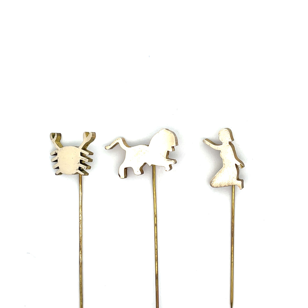 Three decorative sticks with crab, horse, and dancing woman shapes on a white background
