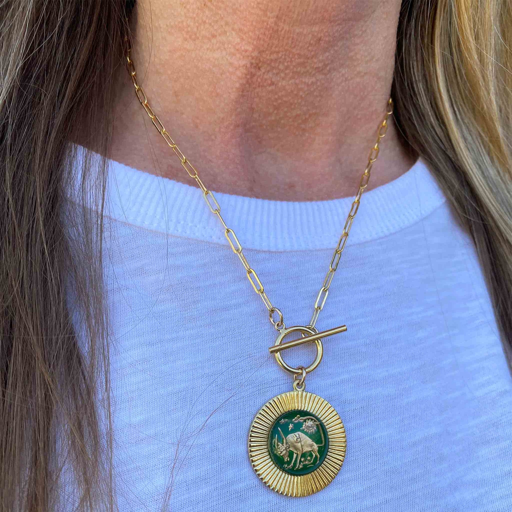 closeup of woman wearing a gold-plated extra large zodiac sign charm