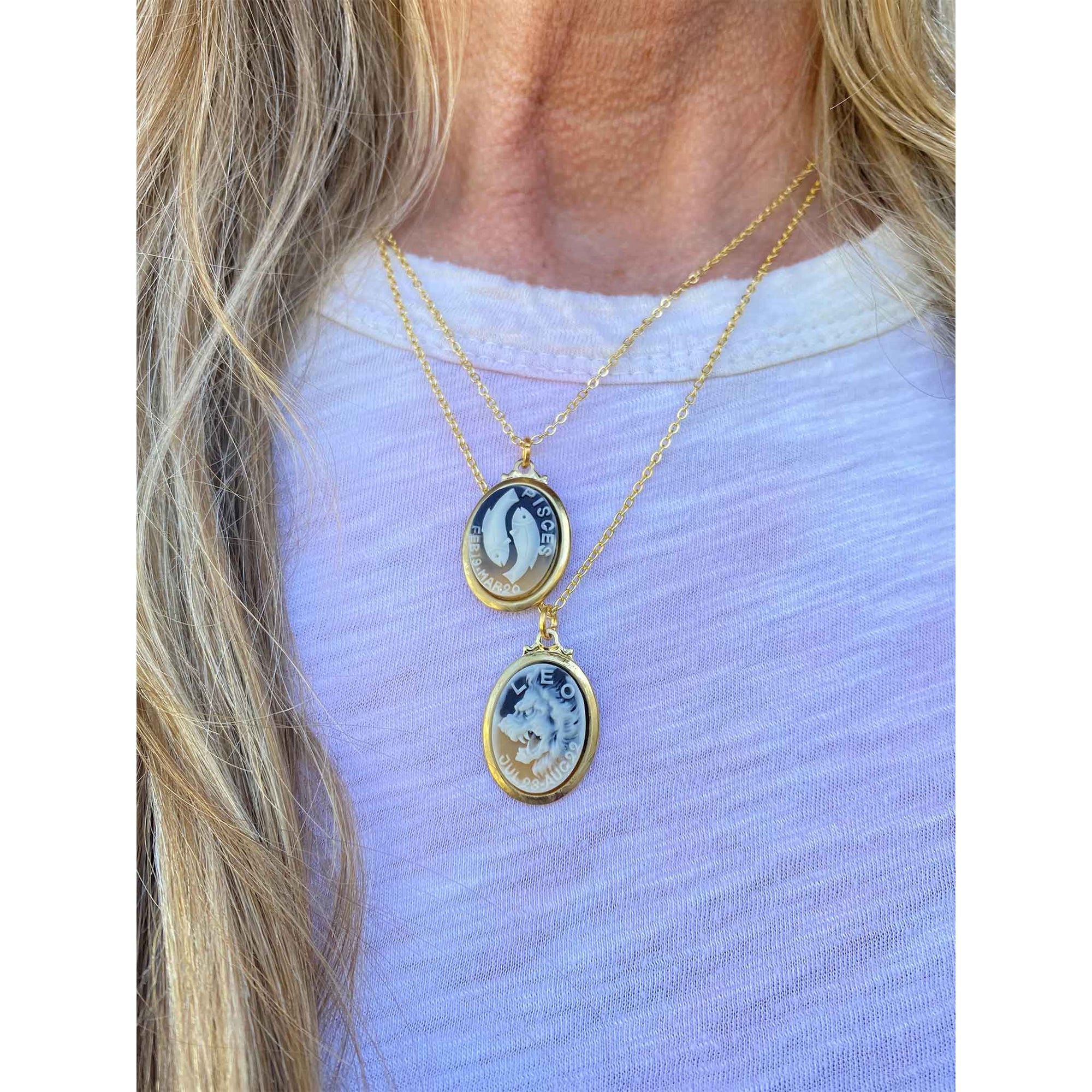 lifestyle image women wearing a necklace with two vintage Japanese cameo style zodiac sign charms in Pisces and Leo